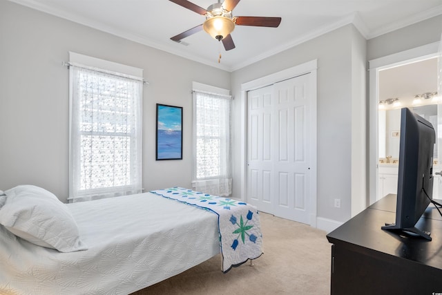 carpeted bedroom with ceiling fan, crown molding, and a closet