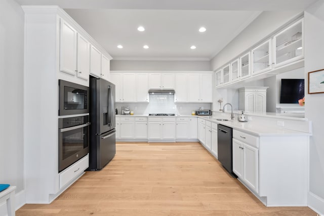 kitchen featuring kitchen peninsula, light hardwood / wood-style flooring, black appliances, sink, and white cabinets