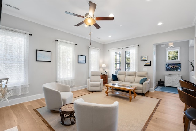 living room featuring light hardwood / wood-style floors, crown molding, and ceiling fan