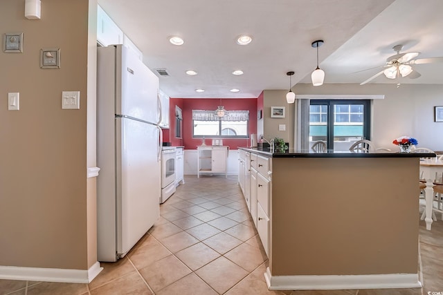 kitchen featuring white appliances, an island with sink, white cabinetry, and pendant lighting