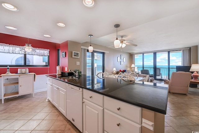 kitchen with light tile patterned floors, dishwasher, a kitchen island, sink, and white cabinetry