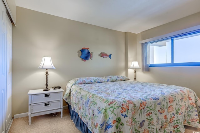 bedroom featuring light carpet and a closet