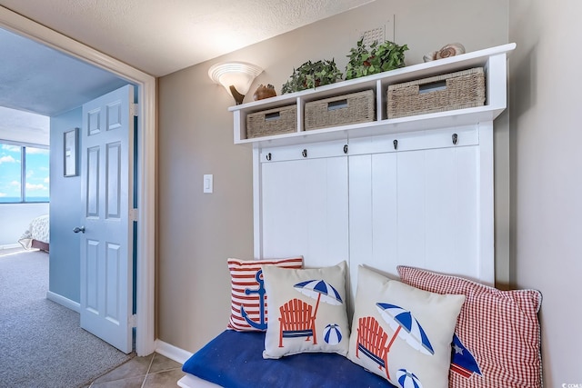 mudroom with light tile patterned flooring and a textured ceiling