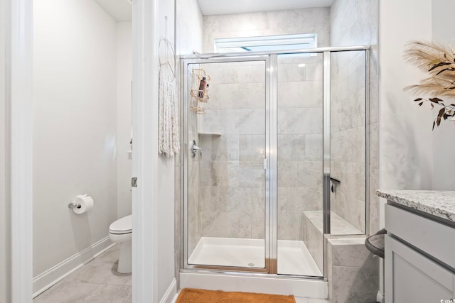 bathroom featuring tile patterned floors, toilet, vanity, and walk in shower