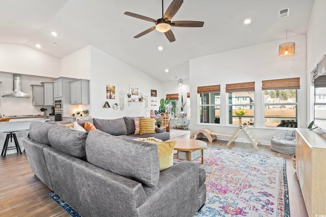 living room with high vaulted ceiling, ceiling fan, and wood-type flooring