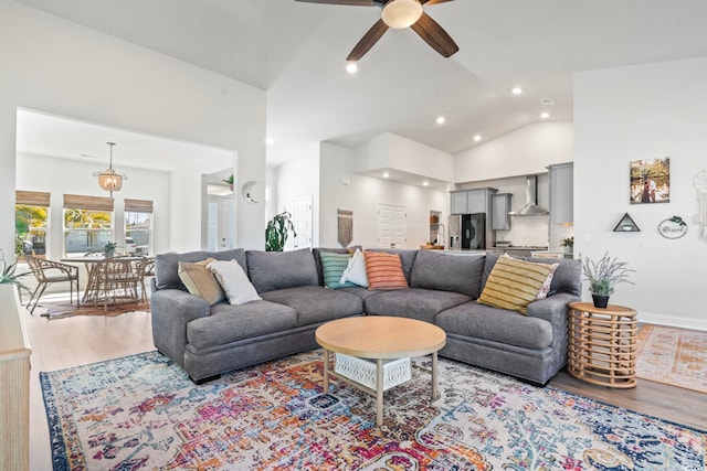 living room featuring high vaulted ceiling, ceiling fan, and light hardwood / wood-style flooring