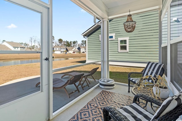 sunroom featuring a water view