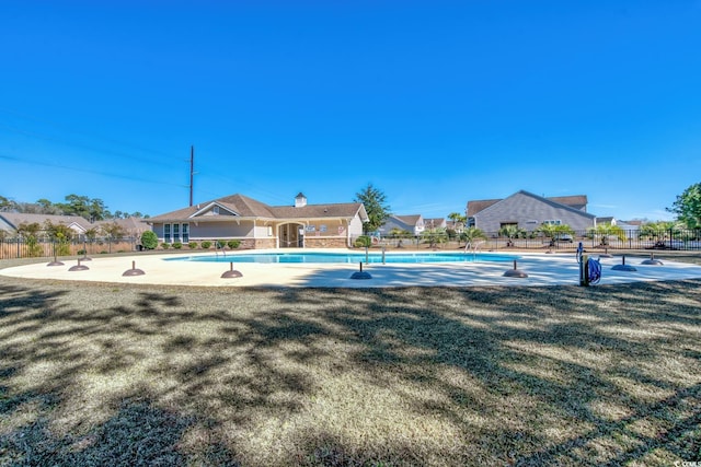 pool with a lawn, fence, and a residential view