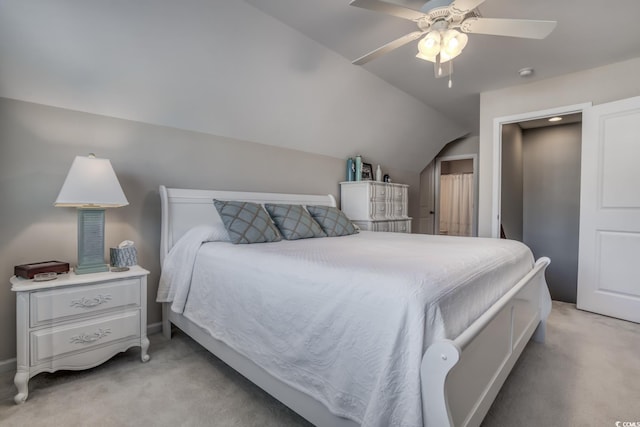 bedroom with lofted ceiling, a ceiling fan, and light colored carpet