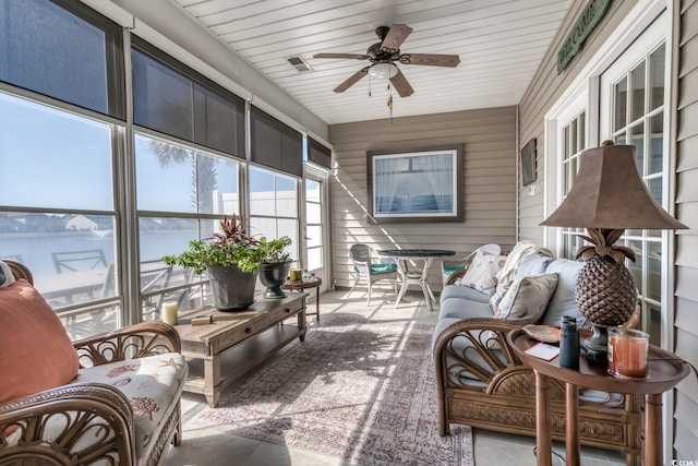 sunroom with a water view and ceiling fan