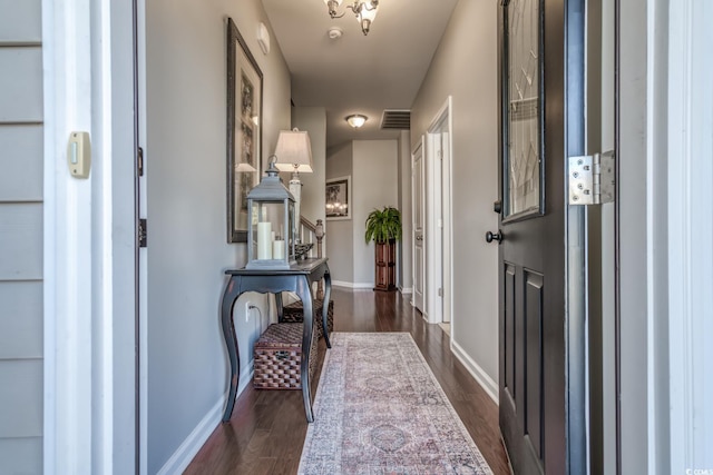 foyer entrance with dark wood-style floors, stairs, visible vents, and baseboards