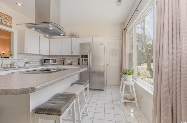 17 Racquet Club Dr, Pawleys Island, SC 29585 - kitchen with stainless steel appliances, island range hood, a sink, a breakfast bar area, and plenty of natural light