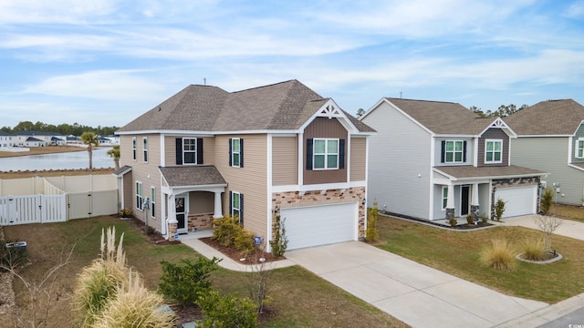 view of front of house featuring a front yard, a garage, and a water view