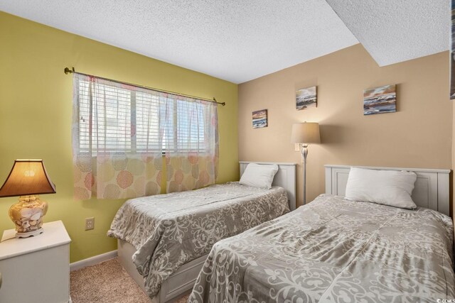 bedroom with carpet floors and a textured ceiling