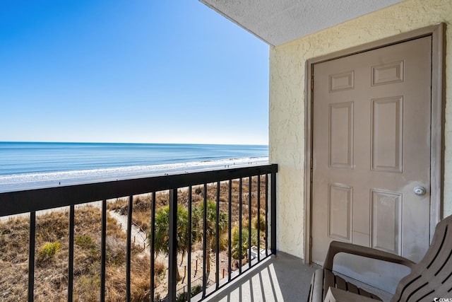 balcony featuring a water view and a view of the beach