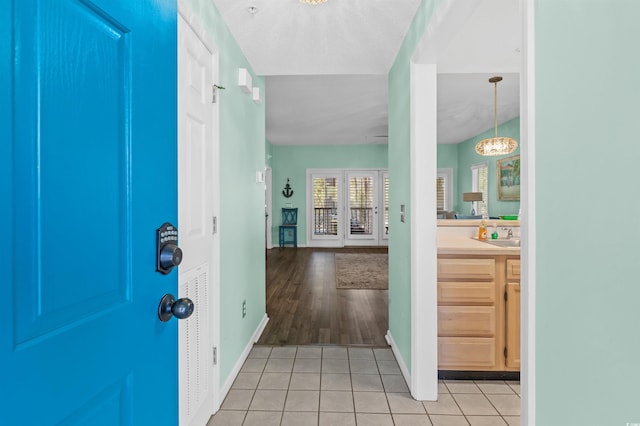 entrance foyer featuring light tile patterned floors, baseboards, and an inviting chandelier