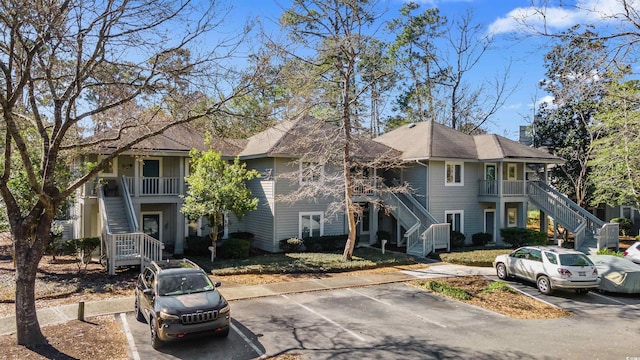 townhome / multi-family property featuring uncovered parking, a porch, and stairway