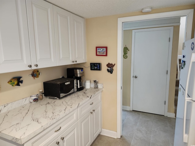219 Salt Marsh Cir Unit 14A, Pawleys Island, SC 29585 - kitchen featuring white cabinets, light countertops, freestanding refrigerator, and light tile patterned floors