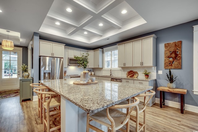 kitchen featuring a kitchen breakfast bar, a kitchen island, stainless steel appliances, and pendant lighting
