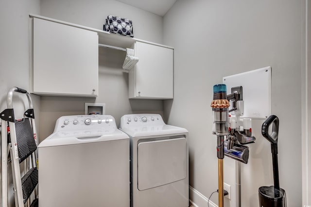 washroom with washer and dryer and cabinets