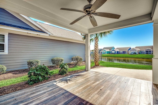 deck featuring a patio, a water view, and ceiling fan