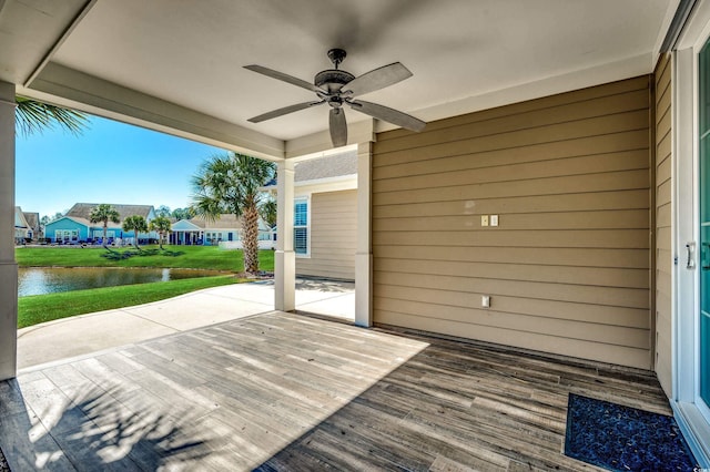 wooden deck with a patio, a water view, and ceiling fan