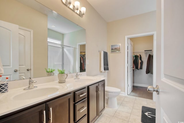 bathroom featuring toilet, vanity, tile patterned flooring, and walk in shower