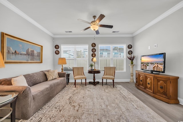 living room with ceiling fan, light hardwood / wood-style flooring, and crown molding