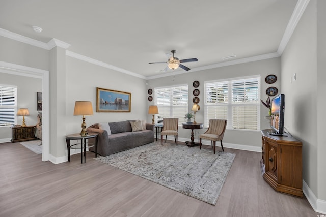 living room with light hardwood / wood-style floors, ceiling fan, and ornamental molding