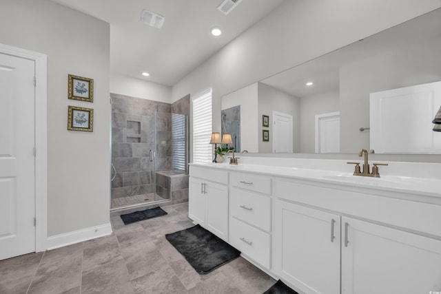 bathroom featuring a tile shower and vanity