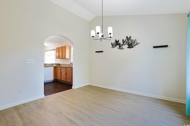 unfurnished dining area with hardwood / wood-style flooring, sink, a notable chandelier, and lofted ceiling