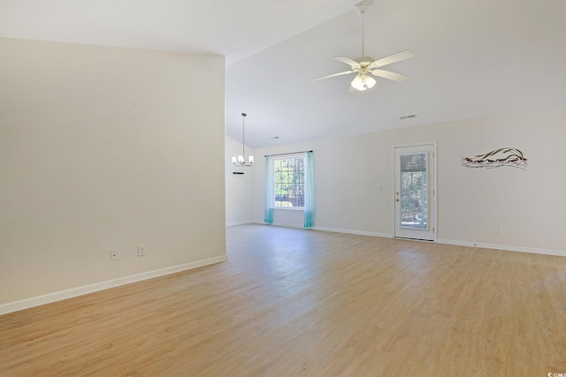 empty room featuring high vaulted ceiling, light hardwood / wood-style floors, and ceiling fan with notable chandelier