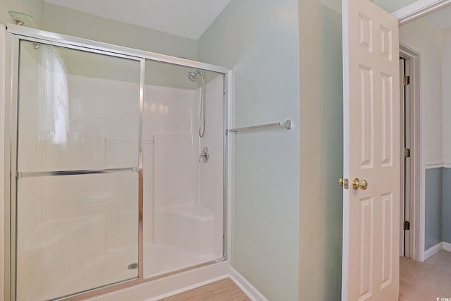 bathroom featuring a shower with door