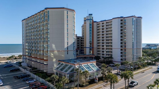 view of building exterior featuring a water view and a view of city