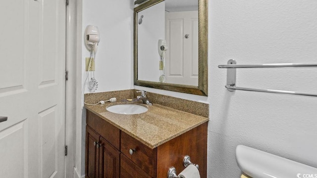 half bath featuring vanity and toilet