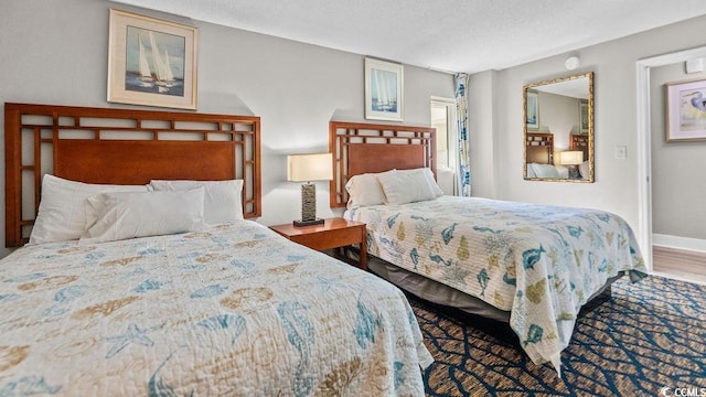 bedroom featuring wood finished floors and baseboards