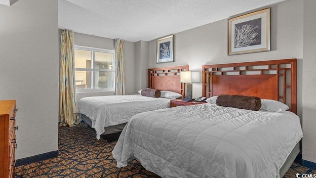 bedroom with baseboards and dark carpet