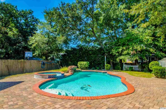 view of swimming pool featuring fence private yard, a pool with connected hot tub, and a patio