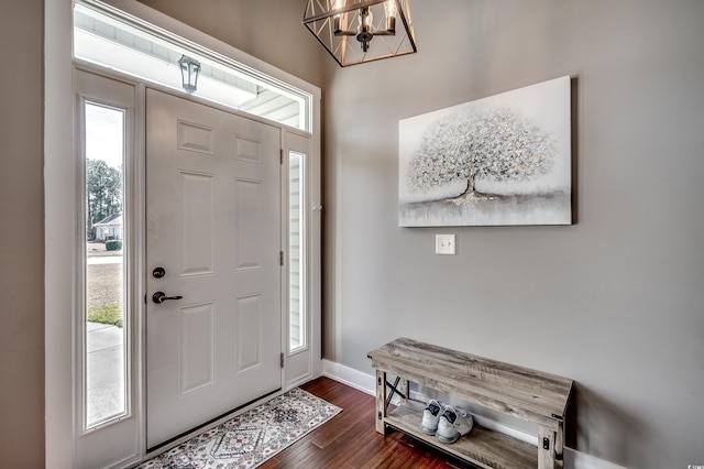 foyer entrance with a chandelier and dark hardwood / wood-style floors