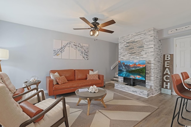 living room with a fireplace, hardwood / wood-style flooring, and ceiling fan