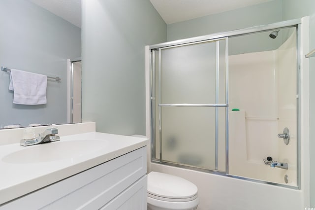 full bathroom featuring combined bath / shower with glass door, vanity, toilet, and a textured ceiling