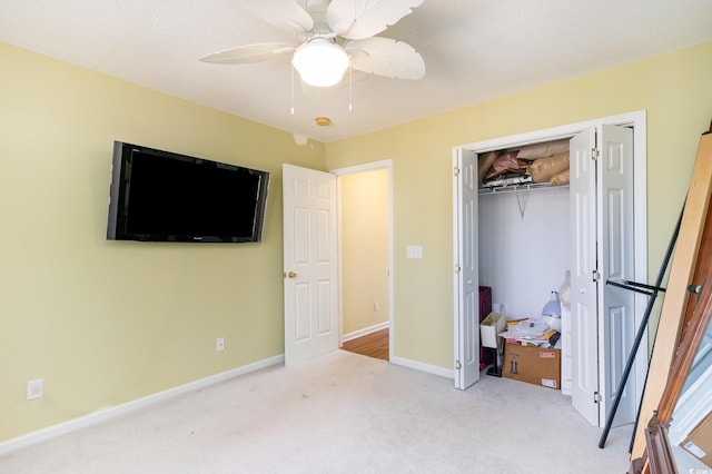 bedroom with a textured ceiling, light carpet, ceiling fan, and a closet