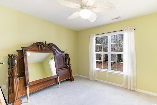 carpeted bedroom with ceiling fan and a textured ceiling