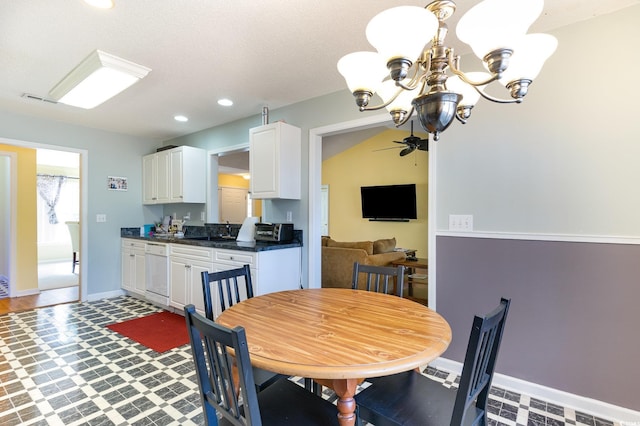 dining space with ceiling fan with notable chandelier and sink