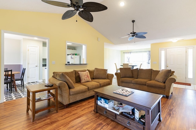 living room featuring ceiling fan, vaulted ceiling, and wood-type flooring