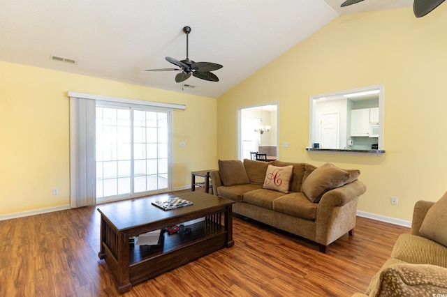 living room with vaulted ceiling, hardwood / wood-style floors, and ceiling fan with notable chandelier