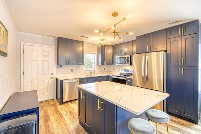 kitchen with light wood-style flooring, stainless steel appliances, a sink, visible vents, and light stone countertops