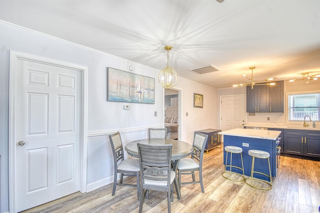 dining space with light wood-style floors, visible vents, and a chandelier