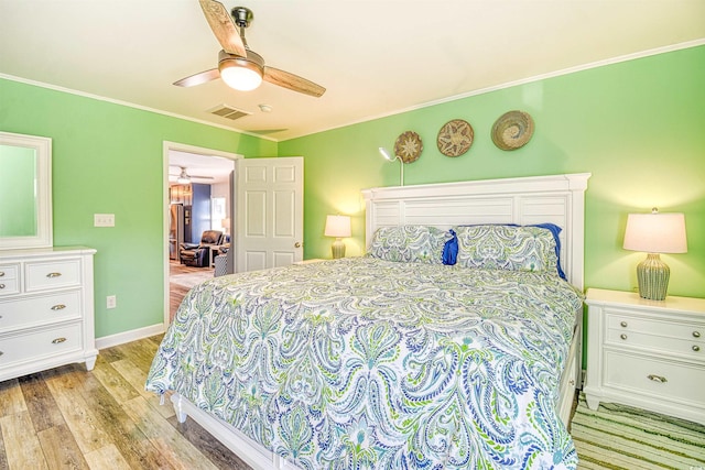 bedroom with ceiling fan, light wood finished floors, baseboards, visible vents, and ornamental molding