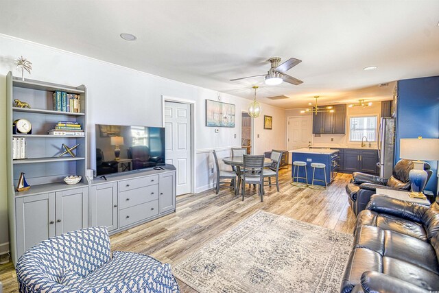 living area with light wood-type flooring and a ceiling fan